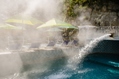 Piscina termale esterna con cascata cervicale e solarium attrezzato.